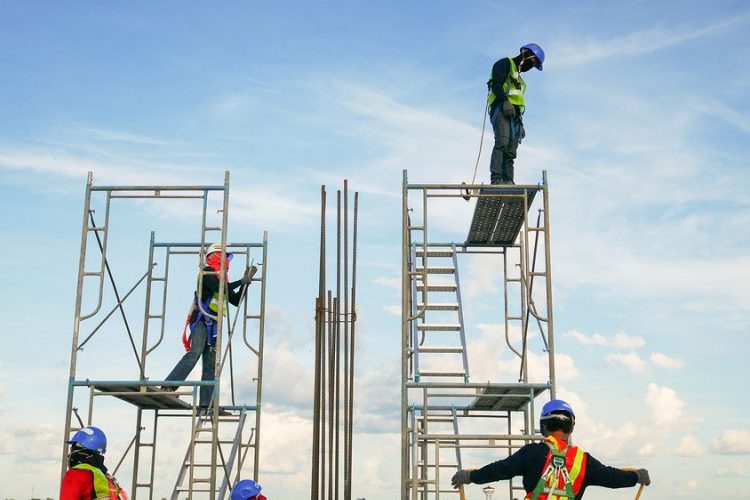 Construction workers climbing on scaffolding